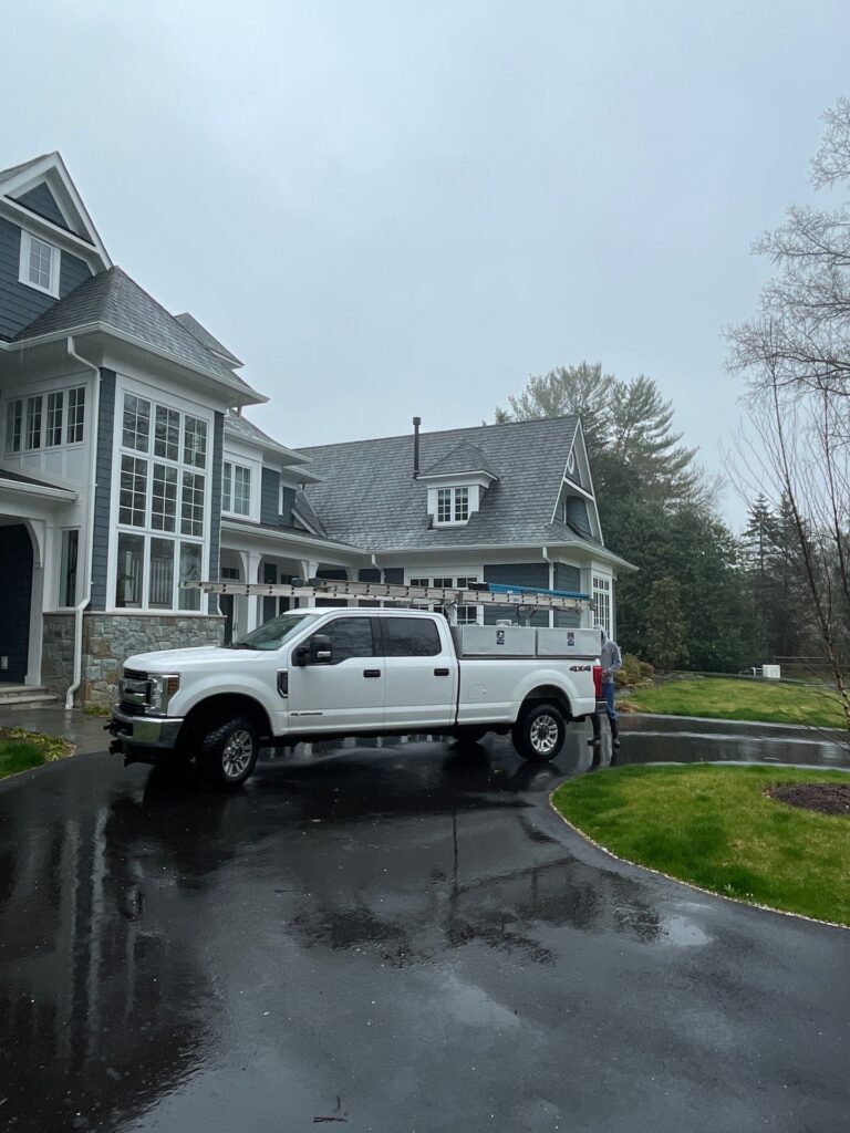 A large white pickup truck in front of a house.